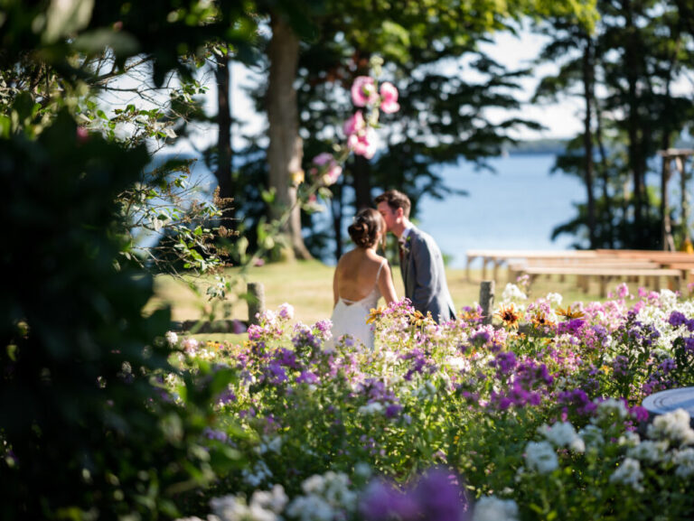 vermont wedding couple by lake champlain and flowers