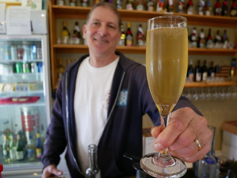 bartender patrick holding up a summer cocktail in a champagne flute
