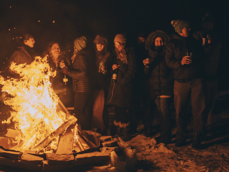 winter white wine bonfire with people drinking around it